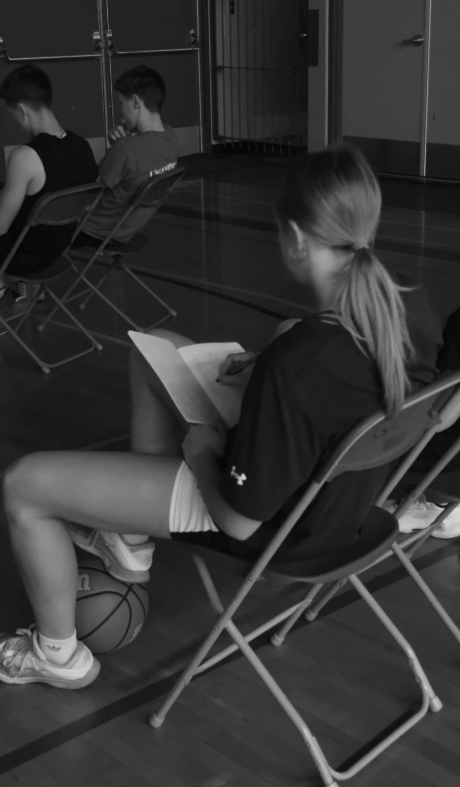 A player writes in her notebook during a classroom session