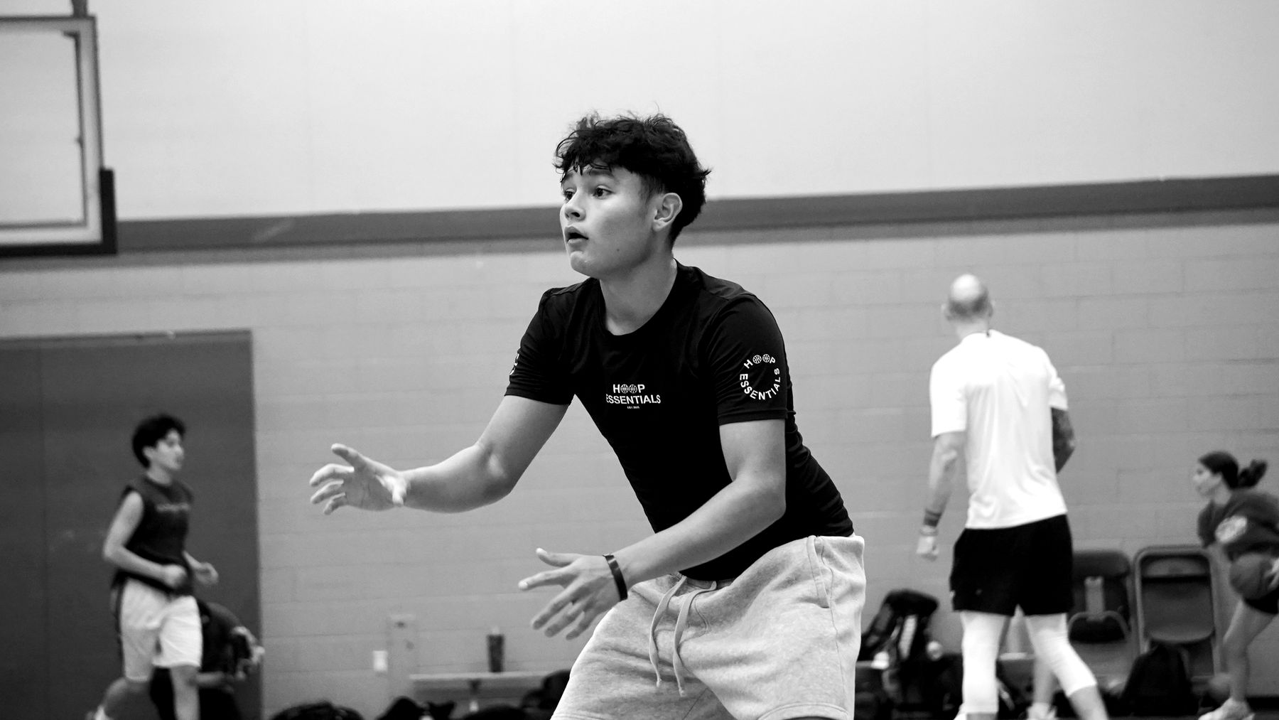 A player in a low defensive stance, hands active