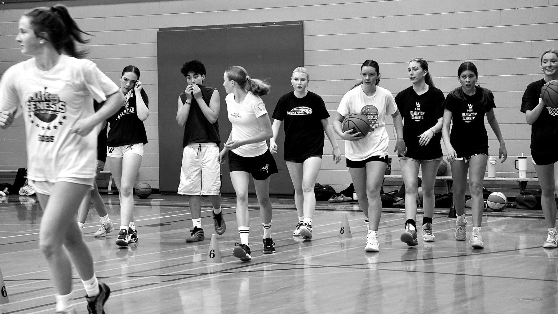 A group of girls running a full-court dribbling drill